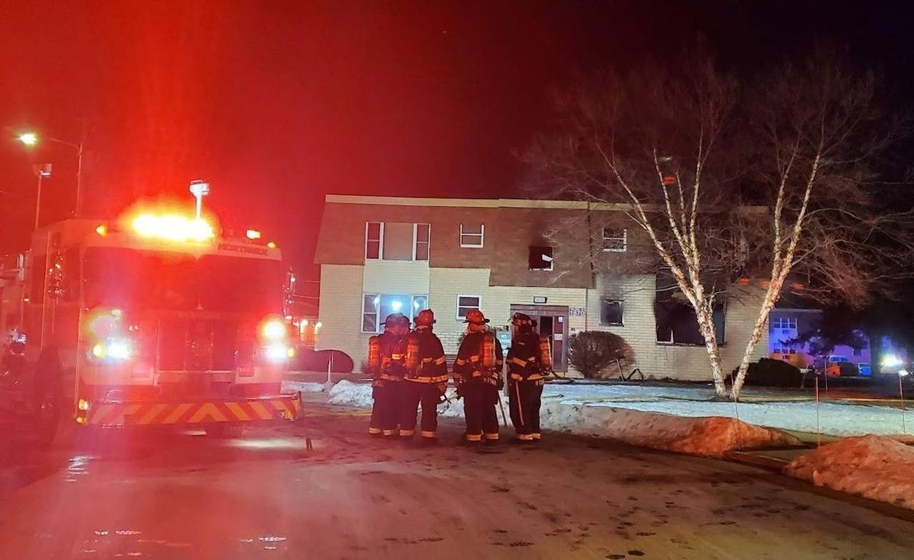 Kenosha firefighters confer at the scene of a deadly blaze Monday, Jan. 18, 2022 in the Saxony Mano...