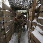 
              Ukrainian servicemen walk in a trench on the front line in the Luhansk region, eastern Ukraine, Friday, Jan. 28, 2022. High-stakes diplomacy continued on Friday in a bid to avert a war in Eastern Europe. The urgent efforts come as 100,000 Russian troops are massed near Ukraine's border and the Biden administration worries that Russian President Vladimir Putin will mount some sort of invasion within weeks. (AP Photo/Vadim Ghirda)
            