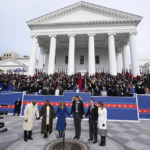 
              Virginia Gov. Glenn Youngkin, third from right, and his wife, Suzanne, third from left, offer a prayer along with Attorney General Jason Miyares, second from right, his wife, Page, as well as Lt. gov. Winsome Earle-Sears, second from left and her husband, Terence, left, join in at the Capitol Saturday Jan. 15, 2022, in Richmond, Va. (AP Photo/Steve Helber)
            