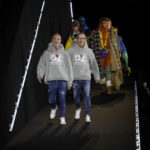 
              Designers Dean Caten and Dan Caten acknowledge the applause at the end of the DSquared F/W 22/23 fashion show, in Milan, Italy, Friday, Jan. 14, 2022. (AP Photo/Luca Bruno)
            