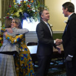 
              Virginia Gov. Ralph Northam greets Gov. elect Glenn Youngkin as Pam Northam, left, empraces Suzanne Youngkin before an inauguration ceremony, Saturday, Jan. 15, 2022, in Richmond, Va. (AP Photo/Steve Helber)
            