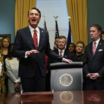 
              Virginia Gov. Glenn Youngkin, second from left, addresses the media as he prepares to sign executive orders in the Governors conference room as Lt. Gov. Winsome Earle-Sears, left, Attorney General Jason Miyares, second from right, and Secretary of the Commonwealth, Kay Cole James, right, look on at the Capitol Saturday Jan. 15, 2022, in Richmond, Va. (AP Photo/Steve Helber)
            