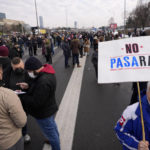 
              A environmental demonstrator holds a banner reading: "No Pasaran" as a highway is blocked, during a protest in Belgrade, Serbia, Saturday, Jan. 15, 2022. Hundreds of environmental protesters demanding cancelation of any plans for lithium mining in Serbia took to the streets again, blocking roads and, for the first time, a border crossing. Traffic on the main highway north-south highway was halted on Saturday for more than one hour, along with several other roads throughout the country, including one on the border with Bosnia. (AP Photo/Darko Vojinovic)
            