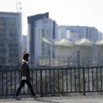 
              A woman wearing a face mask walks across a bridge in the outskirts of Lisbon, Thursday, Jan. 27, 2022. Authorities in Portugal are wrestling with a conundrum: how to hold a general election scheduled for Jan. 30 amid a surge in COVID-19 cases that is confining hundreds of thousands of potential voters to their homes. (AP Photo/Armando Franca)
            