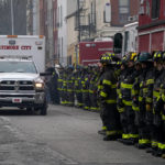 
              Firefighters salute as an ambulance carries a deceased firefighter after they were pulled out of a collapsed building while battling a two-alarm fire at a vacant row home, Monday, Jan. 24, 2022, in Baltimore. Officials said several firefighters died during the blaze. (AP Photo/Julio Cortez)
            