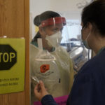 
              Clinical Nurse Supervisor Melinda Chapin, of Holderness, N.H., left, communicates through glass from inside a COVID-19 isolation room with registered nurse Rachel Chamberlin, of Cornish, N.H., right, at Dartmouth-Hitchcock Medical Center, in Lebanon, N.H., Monday, Jan. 3, 2022. Doctors and nurses, once lauded for their service, complain about burnout and a sense their neighbors are no longer treating the pandemic as a health emergency — despite day after day of record COVID-19 cases in the state. (AP Photo/Steven Senne)
            