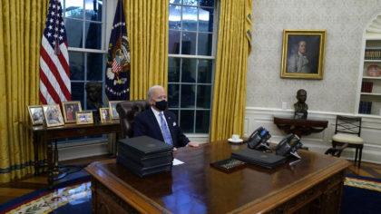 FILE - President Joe Biden pauses as he signs his first executive orders in the Oval Office of the ...