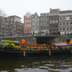 
              People wait on bridges for a free bouquet of tulips in Amsterdam, Netherlands, Saturday, Jan. 15, 2022. Stores across the Netherlands cautiously re-opened after weeks of coronavirus lockdown, and the Dutch capital's mood was further lightened by dashes of color in the form of thousands of free bunches of tulips handed out by growers sailing with a boat through the canals. (AP Photo/Peter Dejong)
            