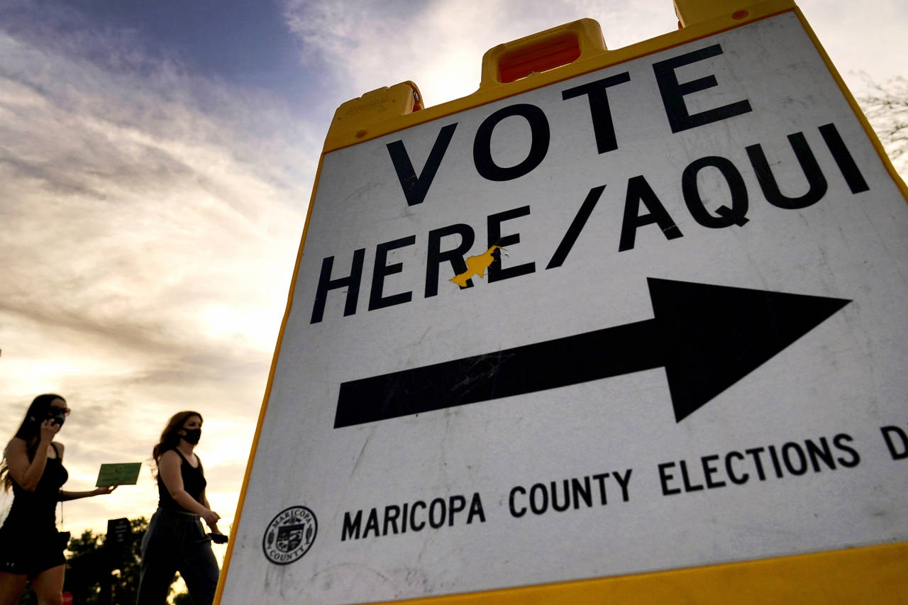 FILE - In this Nov. 3, 2020, file photo, voters deliver their ballot to a polling station in Tempe,...