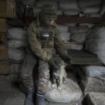 
              A Ukrainian serviceman pats a dog sitting in a shelter on the front line in the Luhansk region, eastern Ukraine, Friday, Jan. 28, 2022. High-stakes diplomacy continued on Friday in a bid to avert a war in Eastern Europe. The urgent efforts come as 100,000 Russian troops are massed near Ukraine's border and the Biden administration worries that Russian President Vladimir Putin will mount some sort of invasion within weeks. (AP Photo/Vadim Ghirda)
            