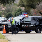 
              Law enforcement officials block a residential street near Congregation Beth Israel synagogue where a man took hostages during services on Saturday, Jan. 15, 2022, in Colleyville, Texas. (AP Photo/Gareth Patterson)
            