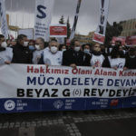 
              Members of the Turkish Medical Association gather outside the Hacettepe University in Ankara, Turkey, Tuesday, Feb. 8, 2022. Healthcare workers go on strike nationwide to protest working conditions and low pay. The banner reads: " We are on strike, we will struggle until we get our rights." (AP Photo/Burhan Ozbilici)
            