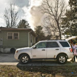 
              Smoke billows in the background as Chakona and Chayla Freeman pack up a car to evacuate their grandmother, Alice Pell, from her home on Indiana Avenue in Winston-Salem, N.C., Tuesday morning, Feb. 1, 2022. Pell's house is very near the Winston Weaver Co. fertilizer plant that caught fire Monday night. The uncontrolled fire at the fertilizer plant forced thousands of people to evacuate as firefighters stood back Tuesday because of the danger of a large explosion.  (Walt Unks/The Winston-Salem Journal via AP)
            