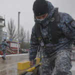 
              A Ukrainian marine border guard walks on the deck of a boat after a patrol in the Sea of Azov, waters near Mariupol, Donetsk region, in eastern Ukraine, Wednesday, Feb. 2, 2022. Russian President Vladimir Putin accused the U.S. and its allies of ignoring Russia's top security demands but said Moscow is willing to talk more to ease tensions over Ukraine. (AP Photo/Vadim Ghirda)
            