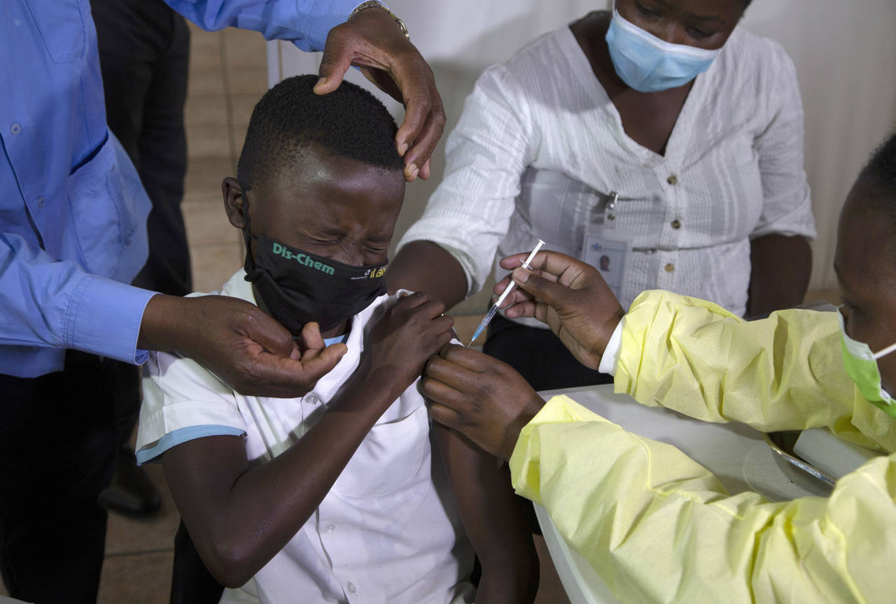 FILE - A child reacts as he receives his Pfizer vaccine against COVID-19 in Diepsloot Township near...