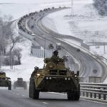 
              FILE - A convoy of Russian armored vehicles moves along a highway in Crimea, Tuesday, Jan. 18, 2022. A buildup of an estimated 100,000 Russian troops near Ukraine has fueled Western fears of an invasion, but Moscow has denied having plans to launch an attack while demanding security guarantees from the the U.S. and its allies. (AP Photo/File)
            
