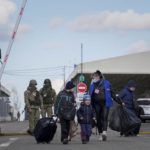 
              A woman with her children crosses a checkpoint from territory controlled by Russia-backed separatists to the territory controlled by Ukrainian forces in Novotroitske, eastern Ukraine, Monday, Feb. 21, 2022. World leaders are making another diplomatic push in hopes of preventing a Russian invasion of Ukraine, even as heavy shelling continues in Ukraine’s east. (AP Photo/Evgeniy Maloletka)
            