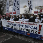 
              Members of the Turkish Medical Association gather outside the Hacettepe University in Ankara, Turkey, Tuesday, Feb. 8, 2022. Healthcare workers go on strike nationwide to protest working conditions and low pay. The banner reads: "We are on strike, we will struggle until we get our rights." (AP Photo/Burhan Ozbilici)
            
