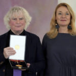 
              Conductor Simon Rattle, left, and his wife Magdalena Kocena, right, pose for the media after Rattle received the 'The Order of Merit of the Federal Republic of Germany' by German President Frank-Walter Steinmeier during a reception at Bellevue palace in Berlin, Germany, Tuesday, Feb. 8, 2022. (AP Photo/Michael Sohn)
            