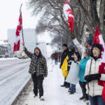 
              People gather in protest against COVID-19 mandates and in support of a protest against COVID-19 restrictions taking place in Ottawa, in Edmonton, Alberta, Saturday, Feb. 5, 2022. (Jason Franson/The Canadian Press via AP)
            