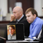 
              Travis Reinking watches a video of himself describing the day he was having, believing someone broke into his home, lifted the toilet seat up and touched his laptop, in court on day four of the mass murder trial at Justice A.A. Birch Building in Nashville, Tenn., Thursday, Feb. 3, 2022. (Stephanie Amador/The Tennessean via AP, Pool)
            