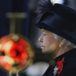
              FILE - Britain's Queen Elizabeth II stands by a cross bearing a poppy during the service of remembrance at the Cenotaph in Whitehall, London, Sunday, Nov. 11, 2012.  Queen Elizabeth II will mark 70 years on the throne Sunday, Feb. 6, 2022 an unprecedented reign that has made her a symbol of stability as the United Kingdom navigated an age of uncertainty. (AP Photo/Kirsty Wigglesworth, File)
            