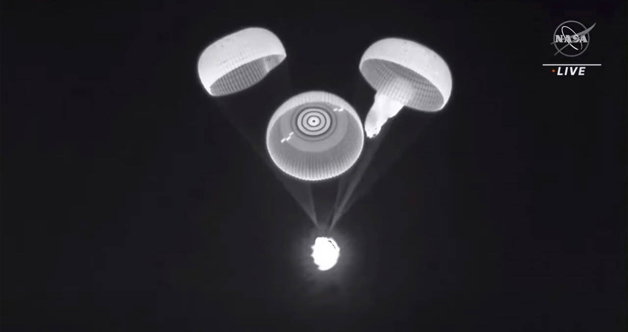 This image provided by NASA shows three of the four parachutes deploying on a cargo ship returning ...