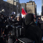 
              Anti vaccine mandate supporters surround and yell at a television news crew during a protest against COVID-19 restrictions, in Toronto, Saturday, Feb. 5, 2022. (Chris Young/The Canadian Press via AP)
            