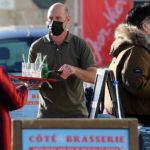 
              A waiter wearing a face mask at a terrace of restaurant talks to person in Saint-Jean-de-Luz southwestern France, Wednesday, Fev.2, 2022. England, France, Ireland, the Netherlands and several Nordic countries have taken steps to end or loosen their restrictions. Step by step, many countries are easing their COVID-19 restrictions amid hopes the omicron wave may have passed its peak. (AP Photo/Bob Edme)
            