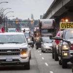 
              A convoy of truckers and their supporters opposed to COVID-19 health measures and vaccinations sits at a standstill after being blocked by counter protesters, in Vancouver, British Columbia, Saturday, Feb. 5, 2022. A group of more than 200 counter protesters on foot and on bikes held up the convoy for nearly an hour before police officers turned the trucks around and sent them on another route. (Darryl Dyck/The Canadian Press via AP)
            