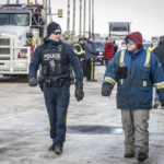 
              An RCMP officer talks with an anti-COVID-19 vaccine mandate demonstrator at road block on the highway in Milk River, Alta., Thursday, Feb. 3, 2022.  (Jeff McIntosh /The Canadian Press via AP)
            