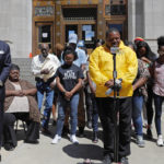 
              FILE - Pastor Linus Mays leads a prayer at the start of a news conference with family of Tommie McGlothen, Jr., outside the Caddo Parish Courthouse with attorney James Carter, left, in Shreveport, La., on, June 10, 2020. The trial of four officers charged in connection with the death of McGlothen, a man who died in police custody in northern Louisiana, will go forward, a judge ruled Thursday, Feb. 3, 2022, rejecting efforts by the four Shreveport officers to have the charges thrown out.  (AP Photo/Gerald Herbert, File)
            