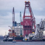 
              FILE - File photo shows tugboats get into position on the Russian pipe-laying vessel "Fortuna" in the port of Wismar, Germany,Jan.14, 2021. The special vessel is being used for construction work on the German-Russian Nord Stream 2 gas pipeline in the Baltic Sea. German Chancellor Olaf Scholz is flying to Washington this week on a mission to reassure Americans that his country stands alongside the United States and other NATO partners in opposing any Russian aggression against Ukraine. (Jens Buettner/dpa via AP, File)
            