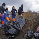 
              FILE - Dead bodies are placed into a mass grave on the outskirts of Mariupol, Ukraine, Wednesday, March 9, 2022, as people cannot bury their dead because of the heavy shelling by Russian forces. (AP Photo/Evgeniy Maloletka, File)
            