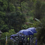 
              Search and rescue workers gather along a road leading into the China Eastern crash site Thursday, March 24, 2022, in Molang village, in southwestern China's Guangxi province. The search area was expanded Thursday in a "blanket search" for the second black box from a China Eastern passenger plane that crashed in southern China with 132 people on board earlier this week, state media said (AP Photo/Ng Han Guan)
            