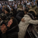 
              FILE - Relatives and friends attend a funeral ceremony for four of the Ukrainian military servicemen, who were killed during an airstrike in a military base in Yavoriv, in a church in Lviv, Ukraine, Tuesday, March 15, 2022. (AP Photo/Bernat Armangue, File)
            