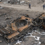 
              Local residents pass at a damaged Russian tank after resent fight in the town of Trostsyanets, some 400km (250 miles) east of capital Kyiv, Ukraine, Monday, March 28, 2022. The more than month-old war has killed thousands and driven more than 10 million Ukrainians from their homes including almost 4 million from their country. (AP Photo/Efrem Lukatsky)
            