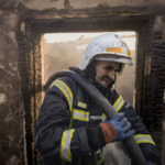 
              Ukrainian firefighters spray water inside a house destroyed by bombing in Kyiv, Ukraine, Wednesday, March 23, 2022. The Kyiv city administration says Russian forces shelled the Ukrainian capital overnight and early Wednesday morning, in the districts of Sviatoshynskyi and Shevchenkivskyi, damaging buildings. (AP Photo/Vadim Ghirda)
            