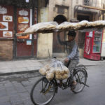 
              A vendor balances a tray of Egyptian traditional "Baladi" flatbread as he cycles in Old Cairo district, Egypt, Tuesday, March 22, 2022. Experts say they are worried that food security concerns in the Middle East resulting from the war in Ukraine may fuel growing social unrest in countries already on the verge of meltdown. (AP Photo/Amr Nabil)
            