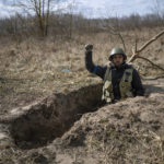 
              Andrii ,31, a soldier from territorial defense, poses for the picture while saying "Glory to Ukraine" during a break from finishing a small trench in Kalynivka, on the outskirts of Kyiv, Ukraine, Sunday, March 27, 2022. (AP Photo/Rodrigo Abd)
            