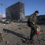 
              A man walks with his dog amid the destruction caused after shelling of a shopping center, in Kyiv, Ukraine, Monday, March 21, 2022. (AP Photo/ (AP Photo/Rodrigo Abd)
            