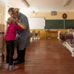 
              Nadia kisses her 10-year-old granddaughter Zlata Moiseinko, suffering from a chronic heart condition, as she receives treatment at a schoolhouse that has been converted into a field hospital in Mostyska, western Ukraine, Thursday, March 24, 2022. The United Nations children’s agency says Russia’s invasion has displaced half of Ukraine’s children, one of the largest such displacements since World War II. (AP Photo/Nariman El-Mofty)
            