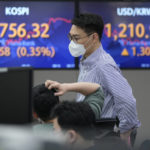 
              A currency trader watches monitors in front of screens showing the Korea Composite Stock Price Index (KOSPI) and the foreign exchange rate between U.S. dollar and South Korean won, right, at the foreign exchange dealing room of the KEB Hana Bank headquarters in Seoul, South Korea, Thursday, March 31, 2022. Asian stock markets sank Thursday after Chinese manufacturing weakened and Russian shelling around Ukraine's capital shook hopes of progress in peace talks. (AP Photo/Ahn Young-joon)
            