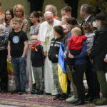 
              Pope Francis, center, poses for a photo with the Ukraine's Ambassador to the Holy See, Andriy Yurash, fourth from right, and a group of Ukrainian mothers and children refugees at the end of his weekly general audience in the Paul VI Hall at The Vatican, Wednesday, March 30, 2022. (AP Photo/Andrew Medichini)
            