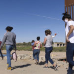 
              FILE - A group of Brazilian migrants make their way around a gap in the U.S.-Mexico border in Yuma, Ariz., seeking asylum in the United States after crossing over from Mexico, June 8, 2021. border. The Biden administration has unveiled new procedures to handle asylum claims at the U.S. southern border, hoping to decide cases in months instead of years. The rules empower asylum officers to grant or deny claims, an authority that has been limited to immigration judges for people arriving at the border with Mexico.  (AP Photo/Eugene Garcia, File)
            