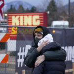 
              FILE - Mourners embrace along a fence put up around the parking lot where a mass shooting took place the day before in a King Soopers grocery store, Tuesday, March 23, 2021, in Boulder, Colo. (AP Photo/David Zalubowski, File)
            