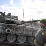 
              A Ukrainian serviceman stands next to a tank in a village of Lukyanivka, Kyiv region, Ukraine, Sunday, March 27, 2022. (AP Photo)
            