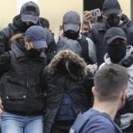 
              A 33-year-old woman, center with the hooded jacket, is escorted by police as she leaves the court in Athens, Greece, Thursday, March 31, 2022. The woman from Patras city, southern Greece, has been charged with the murder of her 9-year-old daughter, following the deaths of her other two young daughters over the past three years, in a case that has drawn national attention. (John Liakos/InTime News via AP)
            