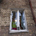 
              Anna looks at the street thought a destroyed window inside her apartment, damaged by shelling, in Kyiv, Ukraine, Wednesday, March 23, 2022. (AP Photo/Rodrigo Abd)
            