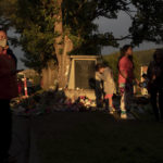 
              FILE - People gather around a makeshift memorial at a monument outside the former Kamloops Indian Residential School, honoring the 215 children whose remains have been discovered buried near the facility, in Kamloops, British Columbia, Friday, June 4, 2021. (Darryl Dyck/The Canadian Press via AP, File)
            